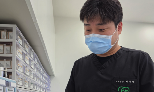 치과의사가 약품이 보관된 서랍 앞에서 약을 확인하는 모습
