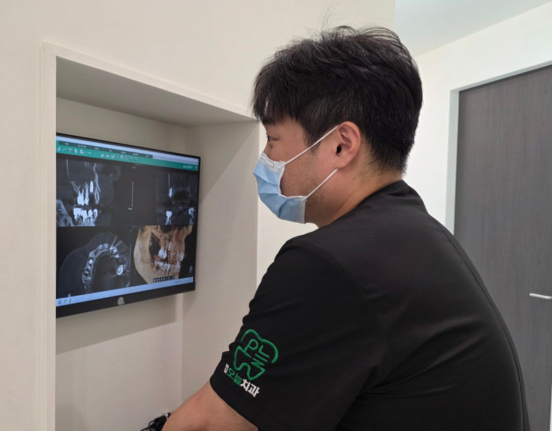 치과의사가 사랑니 CT 영상을 분석한다.