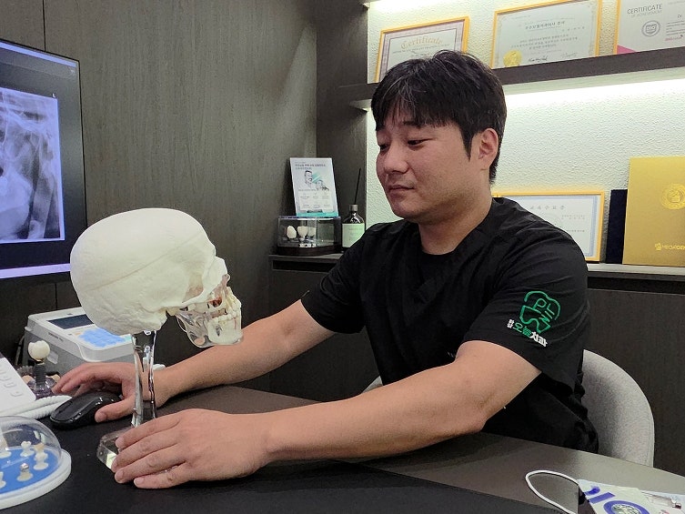 임플란트 뼈이식, 꼭 필요한가요? 뼈가 없으면 임플란트 못하나요? 8 의사가 해골 모형을 보며 설명하고 있다.