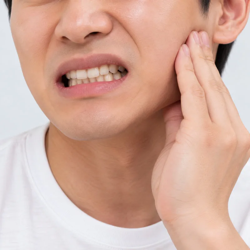 경산치과 임플란트 염증과 교합의 관계 4 턱 부위에 통증을 느끼며 얼굴을 찡그린 남성의 상반신 클로즈업